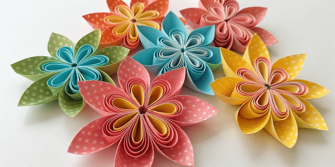 Baa89c81d2f94cfbbd92658ed5fede41 simply paper crafts A photo featuring a variety of origami flowers with a mix of vibrant colors including shades of pink red green blue and yellow