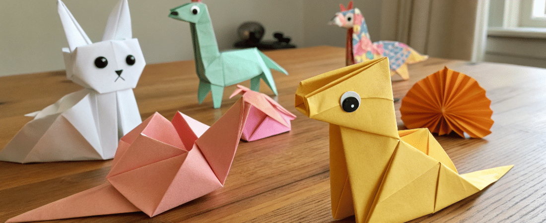 Cute crafts paper simply paper crafts A photo of a collection of origami animals on a wooden table The animals include various species such as rabbits lizards and a snail all crafted from paper with unique folds and shapes