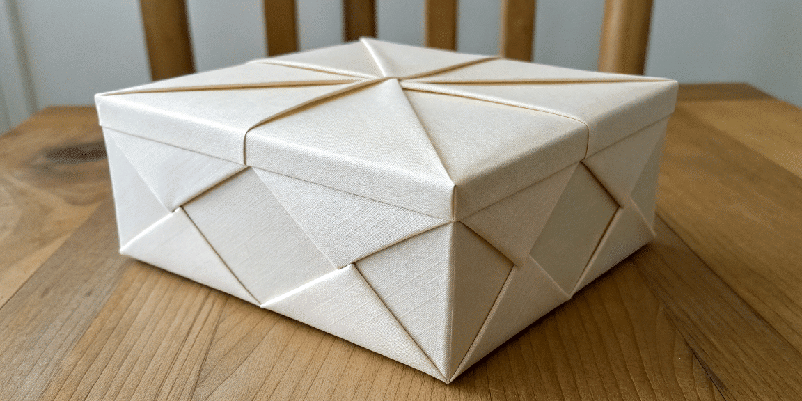 D53e081fb91b40d3bf7c06c8707454c9 simply paper crafts A close up photograph of a white geometrically folded and intricately designed box with a unique symmetrical structure