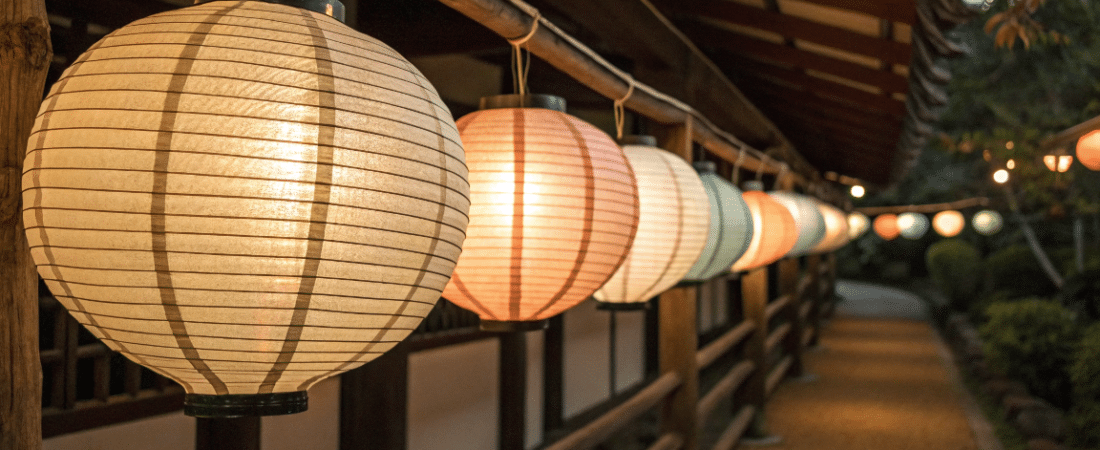 Paper lanterns simply paper crafts A photo of a serene outdoor scene at night with a line of traditional Japanese lanterns hanging along a wooden structure