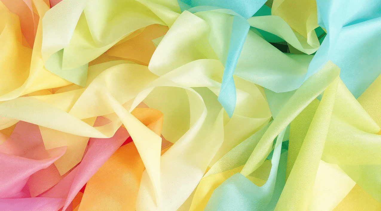 Red, yellow, green and blue tissue paper overlapped.