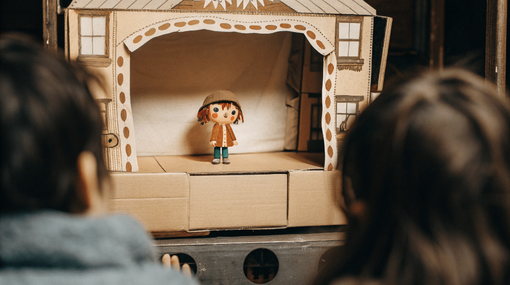 Bringing your puppet to life simply paper crafts A colorful anime paper puppet stands on a small cardboard stage ready for a performance with expressive eyes that bring it to life The scene captures the joy of storytelling and creativity inviting friends to join in the fun of puppet shows and stop motion animation
