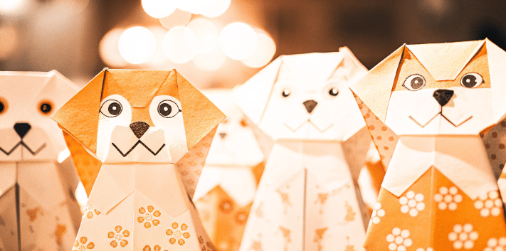 Orange dog origami finger puppet simply paper crafts The image shows a colorful collection of origami finger puppets each uniquely decorated with faces and features ready for storytelling These playful characters are crafted from square pieces of printable origami paper showcasing various animal shapes like dogs and cats highlighting the fun of creating origami puppets with simple folds and decorations