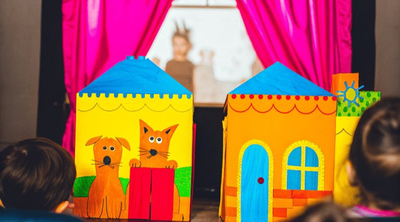 Paper puppet theater for kids simply paper crafts A colorful paper puppet theater scene showcases various handmade puppets including a dog and a fox crafted from cereal boxes and decorated with crayons and paint The vibrant backdrop and side flaps create an imaginative setting inviting children to perform stories and adventures together as a family