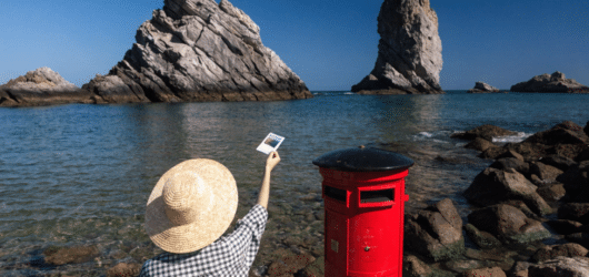 Send a postcard to a friend A person posting a postcard in a letter box