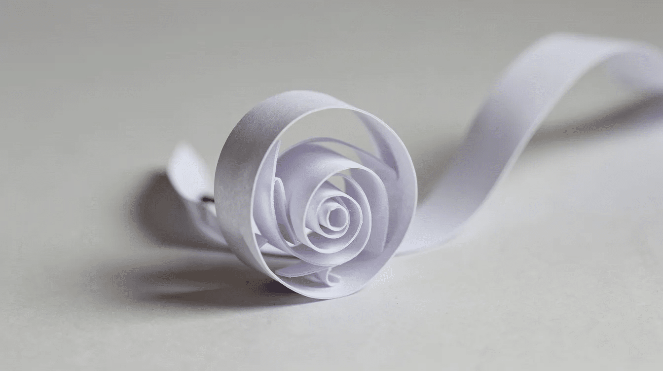 F50a57b1 1da5 48ee bf2b c97225f93674 A spiral cut piece of paper is being rolled into a small rose showcasing the art of making paper flowers with simple materials This charming project highlights the creative potential of tissue paper and is a surprisingly easy way to decorate your home or create a lovely bouquet